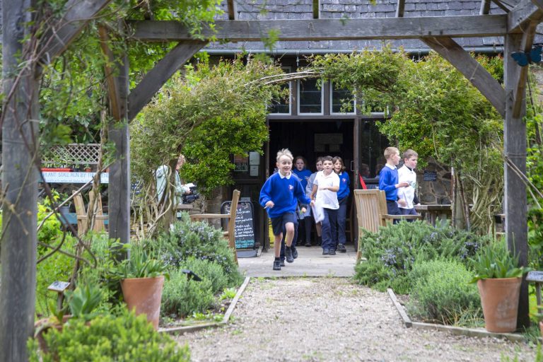 School children running in the gardens of the 1620s house