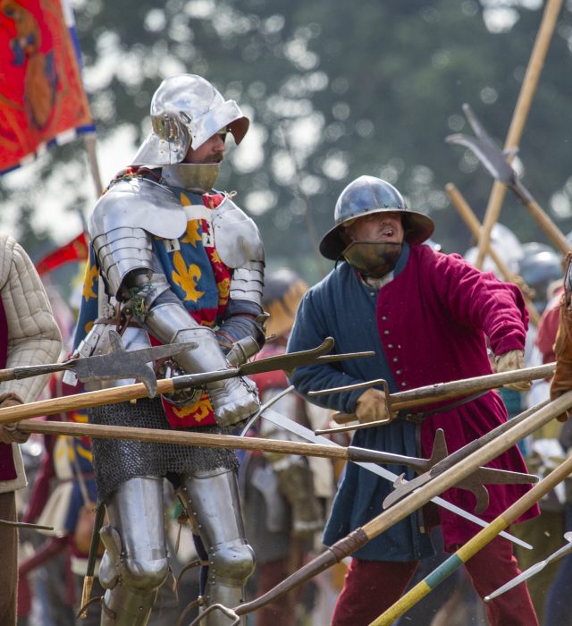 People in Medieval dress holding weapons.